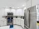 Bright kitchen showcasing stainless steel appliances, granite countertops, tiled backsplash, and ample white cabinetry at 18902 Saint Laurent Dr, Lutz, FL 33558