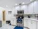 Well-lit kitchen with stainless steel appliances, white cabinets, tile backsplash, and modern fixtures at 18902 Saint Laurent Dr, Lutz, FL 33558