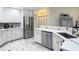 Modern kitchen featuring stainless steel appliances, white cabinetry, a quartz countertop, and tiled flooring at 18902 Saint Laurent Dr, Lutz, FL 33558