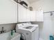 Well-equipped laundry room with white cabinets, a sink, and modern washer and dryer units at 18902 Saint Laurent Dr, Lutz, FL 33558