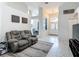 Bright living room with a reclining sofa, open layout, and view into the dining area at 18902 Saint Laurent Dr, Lutz, FL 33558