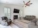Inviting living room featuring a fireplace, a ceiling fan, and a large window at 18902 Saint Laurent Dr, Lutz, FL 33558