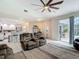 Open living room with a kitchen view and sliding glass doors to an outside entertainment area at 18902 Saint Laurent Dr, Lutz, FL 33558