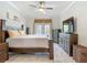 Well-lit bedroom with a bed, two dressers, and tiled floors at 18902 Saint Laurent Dr, Lutz, FL 33558