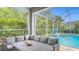 Relaxing screened patio with gray cushioned seating, overlooks sparkling pool and lush greenery at 18902 Saint Laurent Dr, Lutz, FL 33558