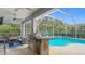 Resort-style outdoor space with a built-in grill, poolside seating, and a screened-in patio, ideal for entertaining at 18902 Saint Laurent Dr, Lutz, FL 33558