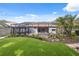 Large backyard with screened-in pool, gazebo, patio, lush landscaping, and artificial grass at 19418 Morden Blush Dr, Lutz, FL 33558