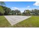 Enjoy a community basketball court with well-maintained surface and hoops in a lush, green park setting under a bright, blue sky at 19418 Morden Blush Dr, Lutz, FL 33558