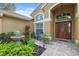 Inviting front porch features tiled flooring, beautiful plants, and an elegant entry door that creates a welcoming entrance at 19418 Morden Blush Dr, Lutz, FL 33558