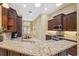 Well-appointed kitchen boasts granite countertops, dark wood cabinets, stainless steel appliances, and seamless dining area access at 19418 Morden Blush Dr, Lutz, FL 33558