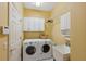 Bright laundry room features a front load washer and dryer set, storage cabinets, and wash sink area at 19418 Morden Blush Dr, Lutz, FL 33558