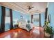 Bright main bedroom features a tray ceiling, ceiling fan, and hardwood floors at 19418 Morden Blush Dr, Lutz, FL 33558