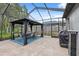 Outdoor dining area inside screened enclosure, complete with paver patio and a grill station at 19418 Morden Blush Dr, Lutz, FL 33558