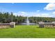 Scenic pond view from a balcony, featuring a water fountain and lush surrounding landscape at 19418 Morden Blush Dr, Lutz, FL 33558