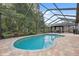Inviting screened-in pool with a gazebo, lush landscaping, and a brick-paved patio area at 19418 Morden Blush Dr, Lutz, FL 33558