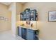 Stylish wet bar features a mini fridge, granite counters, cabinet storage, and decorative accents for elegant entertaining at 19418 Morden Blush Dr, Lutz, FL 33558