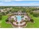 Aerial view of community pool area and clubhouse surrounded by lush landscaping, providing a resort-style amenity at 1987 Trillium Blvd, Brooksville, FL 34604