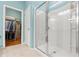 Bright bathroom featuring a glass walk-in shower and a walk-in closet with hardwood floors at 1987 Trillium Blvd, Brooksville, FL 34604