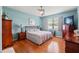 Spacious bedroom with hardwood floors, light blue walls, a comfortable bed, and a ceiling fan at 1987 Trillium Blvd, Brooksville, FL 34604