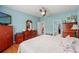 Bedroom featuring hardwood floors, light blue walls, a TV, and access to the en suite bathroom and closet at 1987 Trillium Blvd, Brooksville, FL 34604