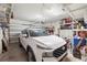 Organized two-car garage featuring ample storage, shelving, and a modern vehicle, blending practicality and style at 1987 Trillium Blvd, Brooksville, FL 34604
