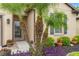 The front entrance landscape features various plants, including palm trees, colorful flowers, and neatly arranged mulch at 1987 Trillium Blvd, Brooksville, FL 34604