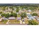 An aerial shot showcases a vibrant neighborhood with tree-lined streets and various single-Gathering homes at 2012 Warrington Way, Tampa, FL 33619