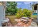 Backyard view with a brick patio, picnic table, and mature landscaping providing shade and privacy at 2012 Warrington Way, Tampa, FL 33619