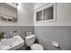 This bathroom features a sink, toilet, window, and tile walls at 2012 Warrington Way, Tampa, FL 33619