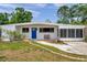 Charming single-story home featuring a bright blue front door and a cozy screened-in porch at 2012 Warrington Way, Tampa, FL 33619