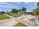 Quaint home featuring a well-maintained yard, screened in porch, and long driveway at 2012 Warrington Way, Tampa, FL 33619
