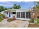 Charming single-story home featuring a bright blue front door and a cozy screened-in porch at 2012 Warrington Way, Tampa, FL 33619