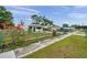 Charming single-story home with a lush, green front yard, accentuated by vibrant pink flowers and a secure chain-link fence at 2012 Warrington Way, Tampa, FL 33619