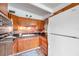 Cozy kitchen with brick backsplash, wood cabinets, and white refrigerator at 2012 Warrington Way, Tampa, FL 33619