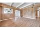 The open living room boasts wood-look floors, wood paneled walls, beams and glass sliding door at 2012 Warrington Way, Tampa, FL 33619