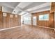 The open living room boasts wood-look floors, wood paneled walls, beams and multiple windows at 2012 Warrington Way, Tampa, FL 33619