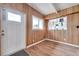 A bright living room features wood-look floors, wood paneled walls, front door and a window with view at 2012 Warrington Way, Tampa, FL 33619