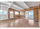 The open living room boasts wood-look floors, beams, glass sliding doors, and wood paneled walls at 2012 Warrington Way, Tampa, FL 33619
