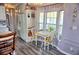 Bright dining area with white table and chairs, complemented by large windows and wood-look flooring at 21040 Lazy Days Cir, Lutz, FL 33558