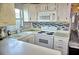 This kitchen features white appliances, cabinets, sleek countertops, and decorative tiled backsplash at 21040 Lazy Days Cir, Lutz, FL 33558