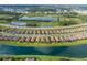 Aerial view of single-Gathering home featuring a screened-in pool and lush landscaping within a community near a lake at 3051 Francoa Dr, Odessa, FL 33556