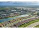An aerial view of single Gathering homes along a waterway with lush landscaping, and terra cotta roofs at 3051 Francoa Dr, Odessa, FL 33556