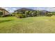 Expansive backyard with vibrant green grass, mature landscaping, and a screened enclosure offering privacy at 3051 Francoa Dr, Odessa, FL 33556