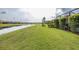 Manicured lawn with a scenic water view and a screened-in lanai for outdoor enjoyment at 3051 Francoa Dr, Odessa, FL 33556