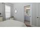 Bedroom includes a window with curtains, a mirror, and a view into an ensuite bathroom at 3051 Francoa Dr, Odessa, FL 33556