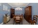Lovely dining room with elegant wooden furniture, wood floors, gorgeous blue walls, and decorative wall art at 3051 Francoa Dr, Odessa, FL 33556