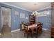 Comfortable dining room offers a wood dining table, decorative lighting, beautiful blue walls, and lovely wood floors at 3051 Francoa Dr, Odessa, FL 33556