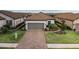 Charming single-story home featuring a two-car garage, tile roof, brick driveway, and manicured landscaping at 3051 Francoa Dr, Odessa, FL 33556