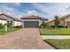 Charming home with a well-maintained lawn and a brick driveway, plus a two-car garage at 3051 Francoa Dr, Odessa, FL 33556