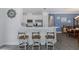 Bright eat-in kitchen features white cabinetry, stainless appliances, bar seating and is open to the dining room at 3051 Francoa Dr, Odessa, FL 33556